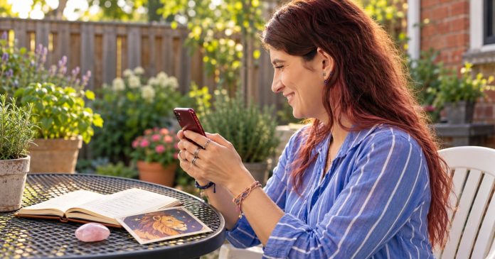 Dating a Leo: Warmth, Romance and Mutual Respect Woman considering relationship questions on a phone beside an astrology journal