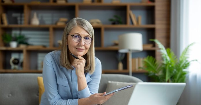 TelePsychics reading guide 2678 A woman reviewing notes beside a laptop in a home office.