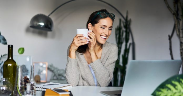 TelePsychics reading guide 2682 A woman with a mug and notebook beside her laptop at home.