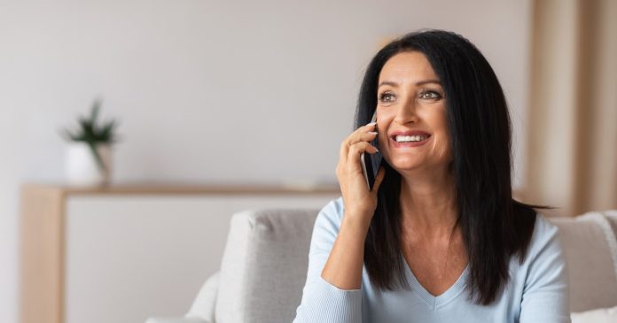 TelePsychics reading guide 2785 A woman having a phone conversation in a bright home setting.