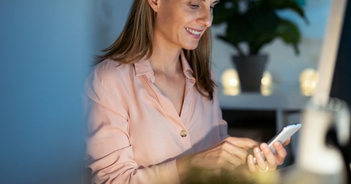 Finding the Right Psychic: Choose a Reader Who Suits You Woman using a smartphone while choosing a reading at home