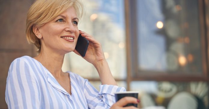 Yes or No Psychic Questions: How to Get a Fuller Reading Woman holding a phone and a cup during a conversation