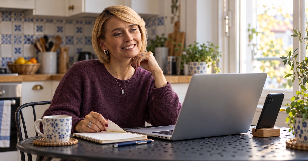 Woman reviewing reading options on a laptop with her phone nearby